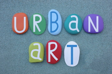 Urban art, visual art created in public locations, creative text composed with multi colored stone letters over green sand