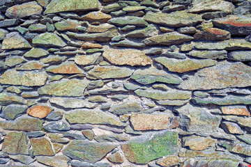 The texture of the masonry wall of natural stone. Detail of a stone wall with different size of rocks.