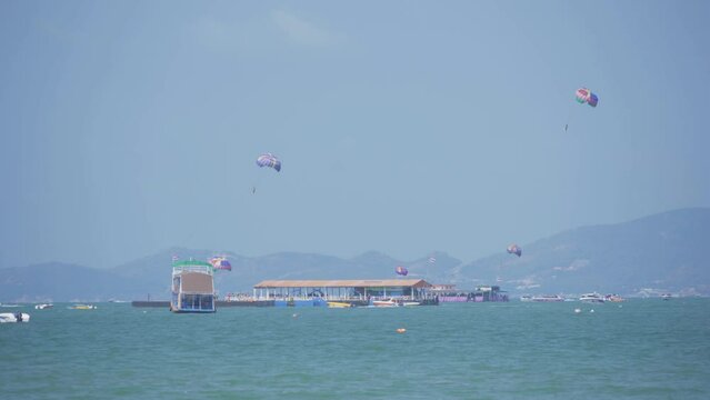 People flying in a colorful parachute or parasail together with blue sky and clouds in freedom and travel concept.