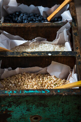 Selective approach to brown yamani rice detelle in pan with other cereals behind.
