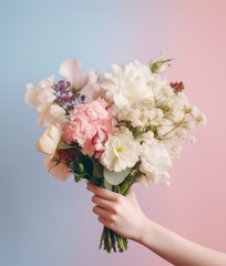 Female hand holding bouquet of flowers.