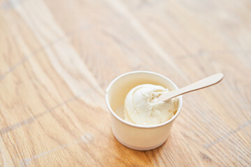 Vanilla ice-cream in disposable cups on the table. Italian gelateria. Natural fresh gelato. 