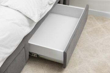 Storage drawer for bedding under modern bed in room