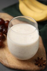 Glass of delicious date smoothie on wooden board, closeup