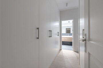 Hallway bedroom with white wood cabinets,