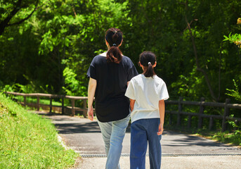 Obraz premium 夏の公園で楽しく散歩している親子の姿