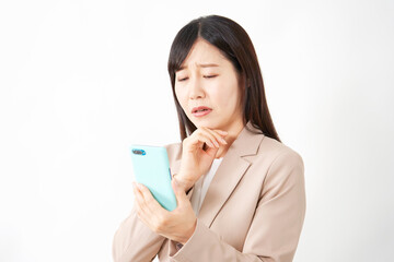 スマートフォンを持って困るミドルエイジのビジネスウーマン　白背景