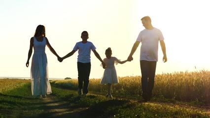 Naklejka na ściany i meble mother father child daughter son walk sunset, holding hands parents girl boy, happy family, wheat field, childhood dream, day off, jogging walk, parents child run sunset, concept cheerful childhood
