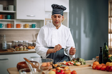 The professional master chef prepares a bowl of various types of fruit and vegetable salad with great passion and enthusiasm. Expertly mix all the ingredients and materials with care and precision.