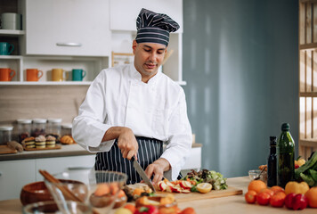 The professional master chef prepares a bowl of various types of fruit and vegetable salad with great passion and enthusiasm. Expertly mix all the ingredients and materials with care and precision.