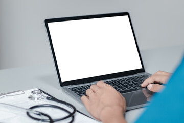 Mockup of doctor using and typing on laptop with blank white desktop screen.