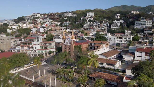 Enthralling drone footage encircles the Parroquia Nuestra Señora del Refugio, offering expansive views of Puerto Vallarta, the majestic Sierra Madre mountains, and the vibrant surrounding areas.
