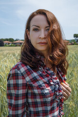 Portrait of a happy caucasian woman in the field of wheat close up