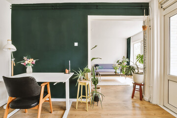 a living room with dark green walls and white trim on the walls there is a black chair in the corner
