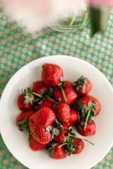 ripe strawberries on a white plate on a bright background. summer berries. seasonal fruits
