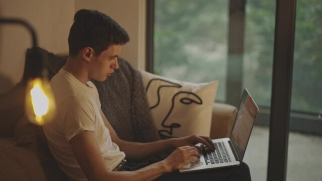 Man Using Laptop In The Living Room At Home - side view