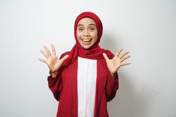 Asian Muslim businesswoman in red casual clothes pointing both hands up on white background
