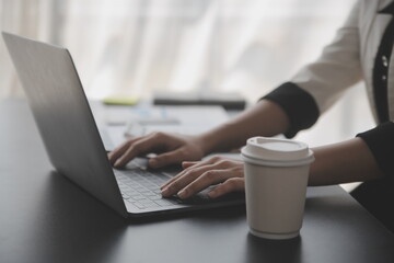 Shot of a asian young business Female working on laptop in her workstation.