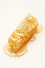 Honey and honeycomb, golden yellow syrup, indoors, close-up, clean background