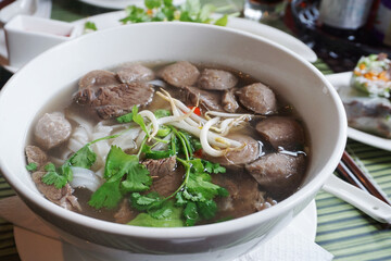 Pho Bo traditional Soup with beef, rice noodles, ginger, lime, chili pepper in bowl. Close up....
