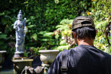 A tourist is praying and wishing to the statue of Lakshmi or Shri the goddess of wealth, fortune,...