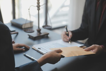 Business and lawyers discussing contract papers with brass scale on desk in office. Law, legal services, advice, justice and law concept picture with film grain effect