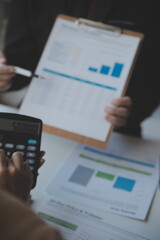 Asian Business woman using calculator and laptop for doing math finance on an office desk, tax, report, accounting, statistics, and analytical research concept