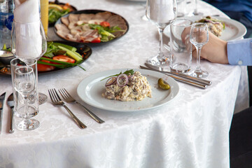 Mushroom salad on a white plate with fork and knife
