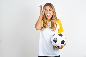 Young beautiful woman wearing football T-shirt over white background goes crazy as head goes around...