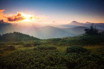 A breathtaking view of the mountain ranges illuminated by the sun's rays.