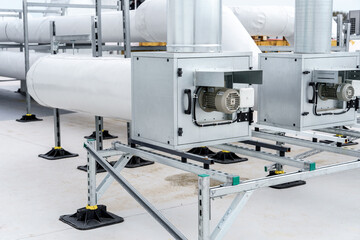 The air conditioning and ventilation system of a large industrial building is located on the roof. It consists of air ducts, air conditioning, smoke removal and ventilation