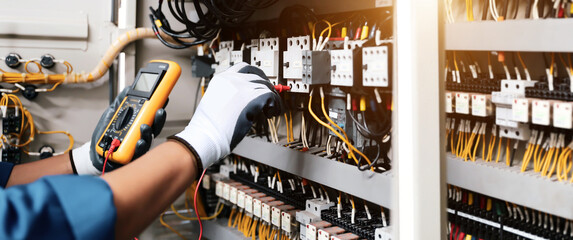 Electricity and electrical maintenance service, Engineer hand checking electric current voltage at circuit breaker terminal and cable wiring in main power distribution board. - obrazy, fototapety, plakaty