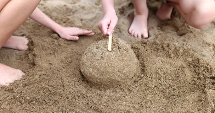 Children hands play and build sand castles on beach in summer. Happy kids rest and play with sand