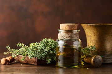 Bottle of thyme essential oil with fresh thyme.