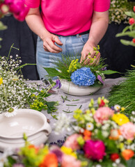 Obraz na płótnie Canvas Florist arrangiert bunte Blumen in einem Gefäß aus Keramik, Blumengesteck mit frischen Blumen, 
