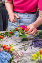 Obraz na płótnie Canvas Florist arrangiert bunte Blumen in einem Gefäß aus Keramik, Blumengesteck mit frischen Blumen, 