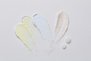 Aesthetic beautiful textured smears in different color over a light background. Concept of skin care routine. Flat lay
