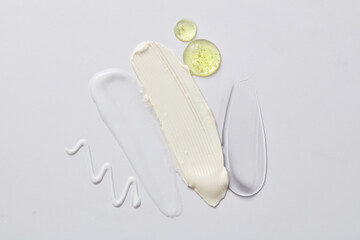 Natural skin care concept of serum drops in yellow color and some cosmetic texture smears. Cosmetic...