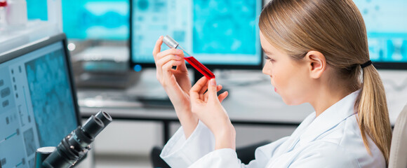 Professional female scientist is working on a vaccine in a modern scientific research laboratory. Laboratory tools: microscope, test tubes, equipment. Future technology, healthcare and science.