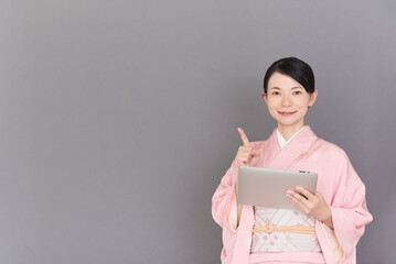 Obraz premium タブレットを操作する着物を着た女性