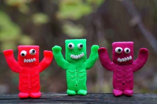 Three colorful plasticine zombies are trying to scare. Funny monster.