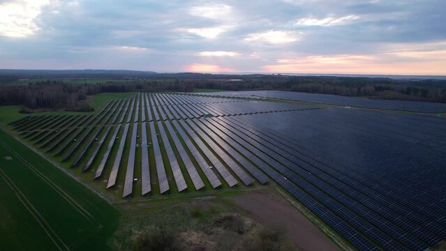 Vast solar farm with long rows of PV solar panels, aerial view