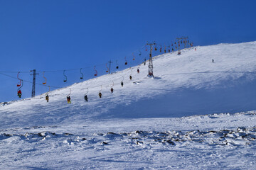 Panorama of the cable car with skiers on Mount Cheget