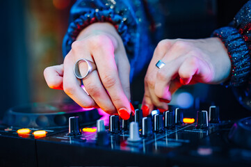 woman DJ Hands creating and regulating music on dj console mixer in concert