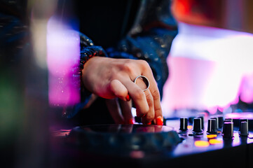 woman DJ Hands creating and regulating music on dj console mixer in concert