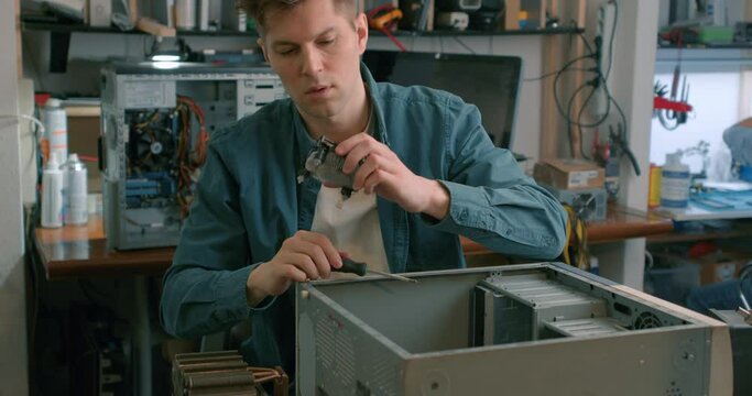 young professional electronic master repaires system block case computer chassis pc tower Slow motion computer engineer working at open computer in bright office. technician working on broken computer