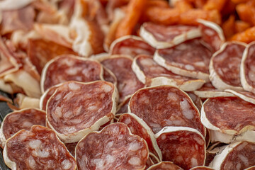 Cured meat with toppings. Homemade salami, chorizo and other cured sausages. Dried sausages cut into thin slices
