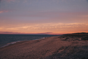 Fototapeta na wymiar Sonnenuntergang am Strand mit Blick auf das Meer und leuchtendem Himmel, Sardinien, Italien