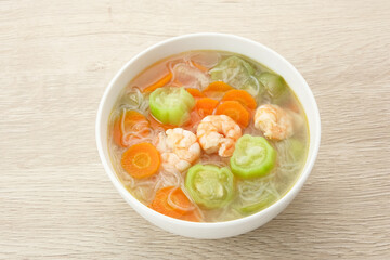 Sayur Oyong Bihun, made from luffa acutangula, carrot, shrimp and vermicelli. Served in white bowl

