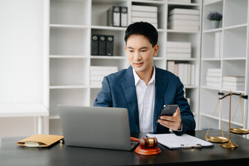 Attractive young lawyer in office Business man and lawyers discussing contract papers laptop and tablet with brass scale on  desk in modern office. Law, legal services, advice,.